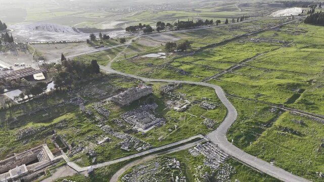 Cinematic aerial drone video of Hierapolis Antik Kenti and Pamukkale travertines in Denizli, Turkey, showcasing the Roman theater, columns, ruins, and dramatic landscape from above.