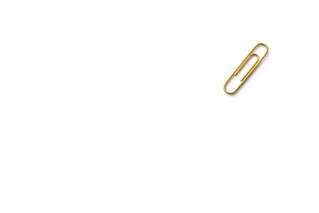 Obraz premium Top down studio photo of a single polished gold paper clip in the upper right corner