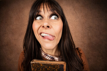 Fototapeta premium Frau mit verrücktem Gesichtsausdruck und herausgestreckter Zunge – humorvolles Weitwinkel Portrait