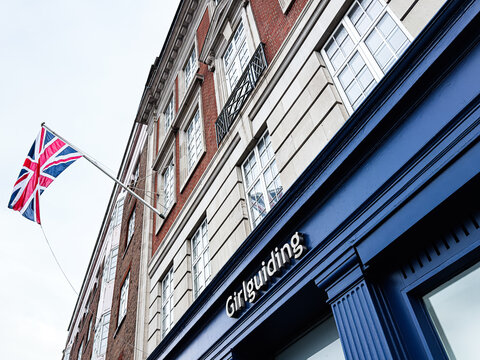 London with blue The Guide Association facade and Union Jack flag near a Girlguiding store in the United Kingdom