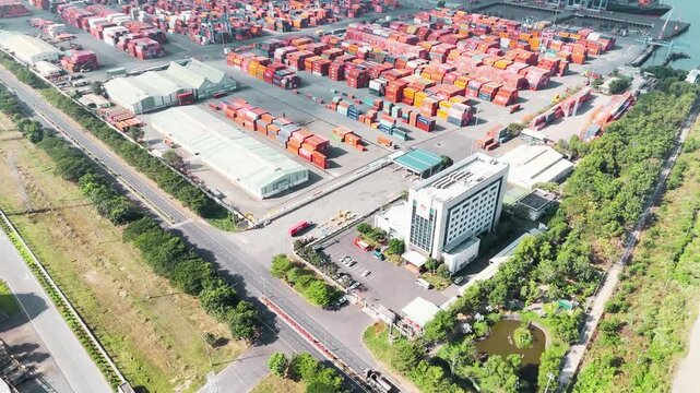 Aerial drone view of large Asian logistics dockyard with cargo ships, container cranes and busy maritime transport hub &ndash; 21 November 2026 &ndash; global shipping industry and trade infrastructure cinematic 