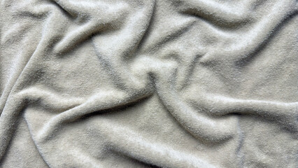 plush fleece blanket texture undulates with cozy rumpled folds and luxurious velvety wrinkles in neutral beige tones © Arthur