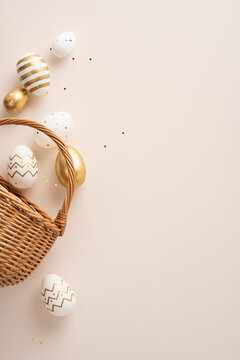 Elegant vertical Easter arrangement featuring a wicker basket with painted gold and white eggs, pastel confetti and minimalist background ideal for greeting card, holiday promotion, spring celebration