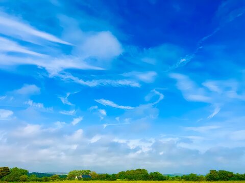 Bright blue skies stretch over rolling green hills inviting joyful exploration and adventure on a sunny day
