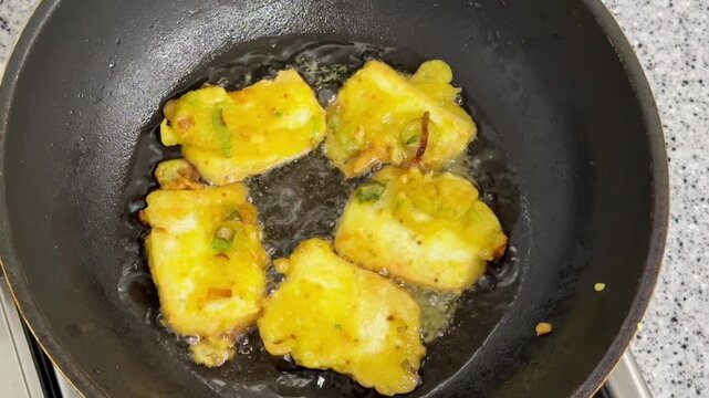 Indonesian traditional food Tahu Goreng or Fried Tofu.Cubes Deep Frying in Hot Oil with Bubbling Texture Close Up