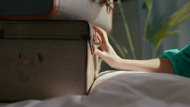Soft morning light reveals a hand opening a vintage suitcase. Person rests on bed, ready for travel. Calm, nostalgic mood evokes wanderlust and adventure. Ideal for travel blogs, vacation ads