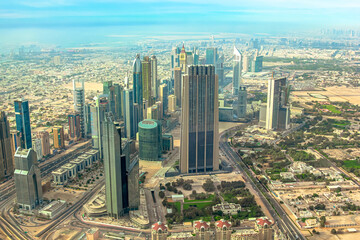 Obraz premium Downtown Dubai showcasing its dynamic cityscape with towering skyscrapers, advanced infrastructure, and expansive urban development extending into surrounding desert landscape in United Arab Emirates