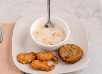 bowl of clam chowder with shrimp and crab cakes