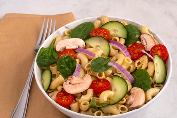 macaroni top with   cucumbers, tomato and spinach
