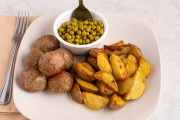  italian meatballs  with  potato wedges and peas