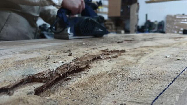 Authentic Faceless Maker Delivering Tangible Results on Raw Timber Slab with Power Planer Tracking Shot