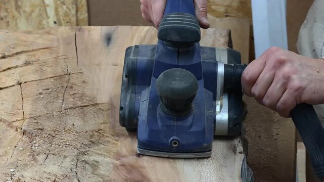 Extreme Close Up of Industrial Electric Planer Smoothing Wood Slab Moving Into Camera Lens in Slow Motion