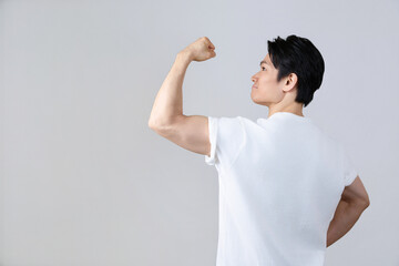 後ろ姿で腕の筋肉を見せる日本人男性 健康とフィットネス