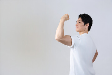 後ろ姿で腕の筋肉を見せる日本人男性 健康とフィットネス