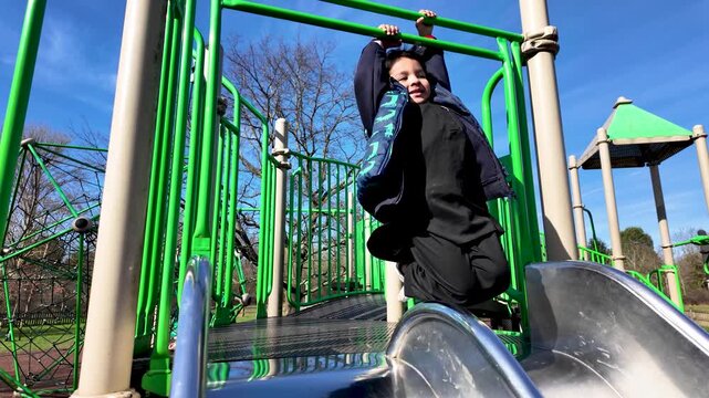Childhood development and outdoor play showing a South Asian boy swinging on monkey bars at a park