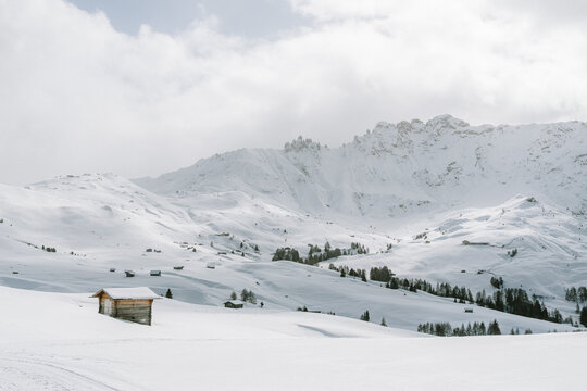 verschneite Landschaft mit Holzh&uuml;tten auf der Seiser Alm
