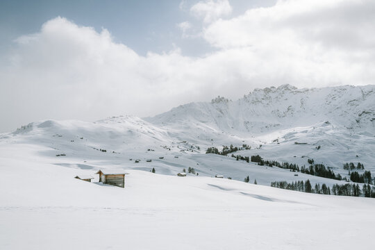 verschneite Landschaft mit Holzh&uuml;tten auf der Seiser Alm