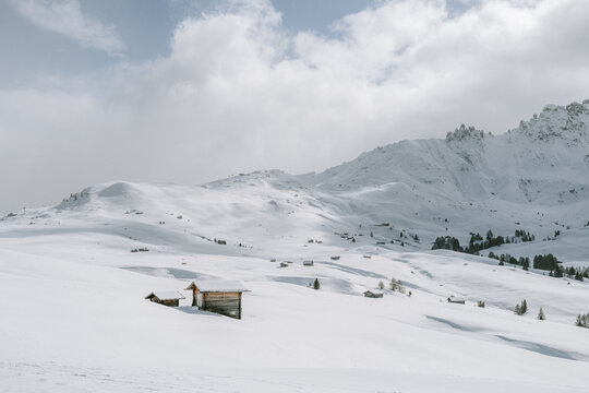 verschneite Landschaft mit Holzh&uuml;tten auf der Seiser Alm