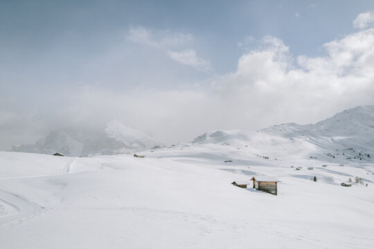 verschneite Landschaft mit Holzh&uuml;tten auf der Seiser Alm