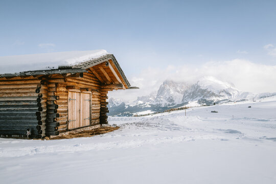 Blick von der Seiser Alm auf das Langkofelmassiv im Winter mit H&uuml;tten, Skipisten und Langlaufloipen im Vordergrund