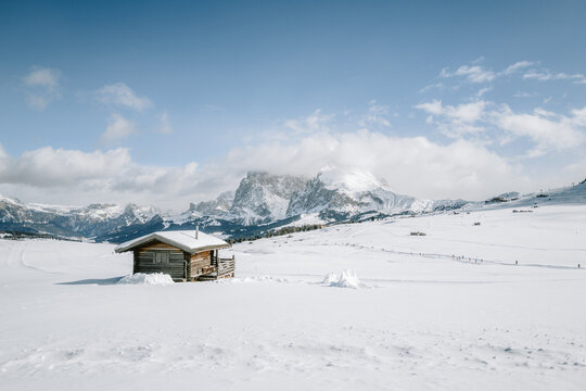 Blick von der Seiser Alm auf das Langkofelmassiv im Winter mit H&uuml;tten, Skipisten und Langlaufloipen im Vordergrund