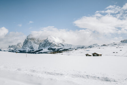 Blick von der Seiser Alm auf das Langkofelmassiv im Winter mit Skipisten und Langlaufloipen