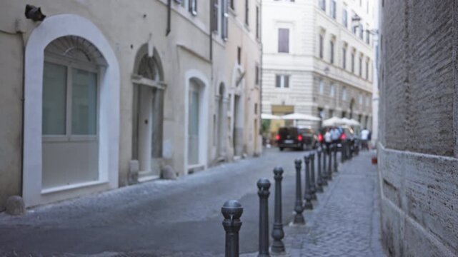 Narrow rome street with soft blurred bokeh focus, defocused building facades and cobblestone pavement; backdrop copyspace backplate.