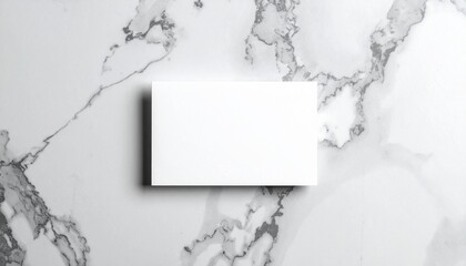 グレー大理石の背景に置かれた1枚の白い名刺のシンプルなオーバーヘッドショット