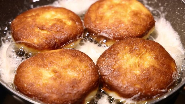 Golden brown doughnuts frying in hot oil pan for traditional Fat Thursday celebration homemade sweet pastry dessert cooking process and delicious culinary snack background.