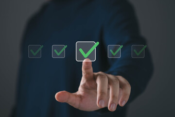 Close up of hand touching virtual checkbox with green check mark, symbolizing approval, quality...