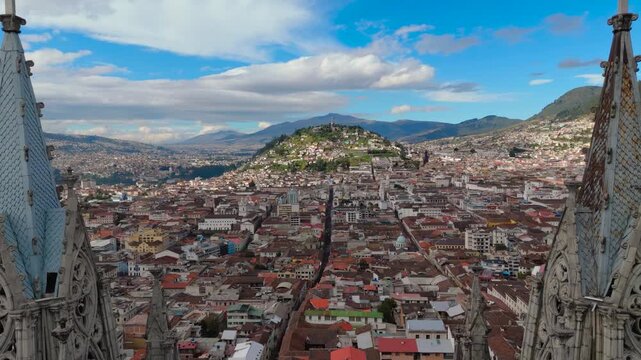 Reveal shot of the Virgin of El Panecillo, seen from between the towers of the Basilica of the National Vow in Quito, Ecuador
