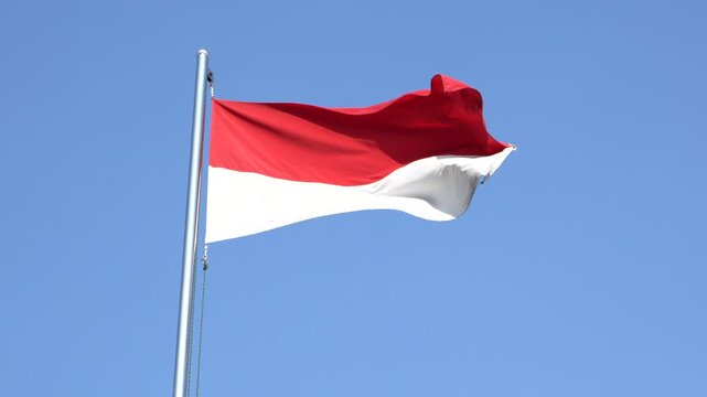 The single large red and white Indonesian flag flutters in the strong wind ahead of the 77th Independence Day of the Republic of Indonesia.	
