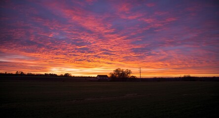 Fototapeta premium Colorful sunset sky over peaceful countryside house