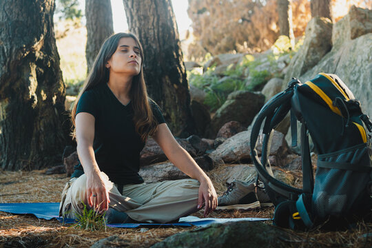 Mujer joven haciendo ejercicios de estiramiento y respirando aire fresco. Salida para el dia mundial del medio ambiente