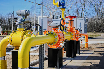 Gas pipeline equipment featuring orange and yellow pipes with connecting valves and control units