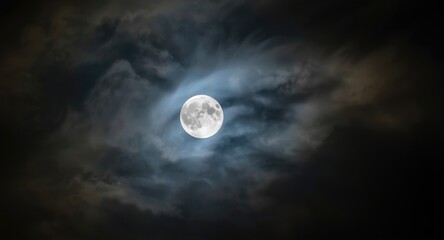 Fototapeta premium Bright full moon peeking through light wispy clouds