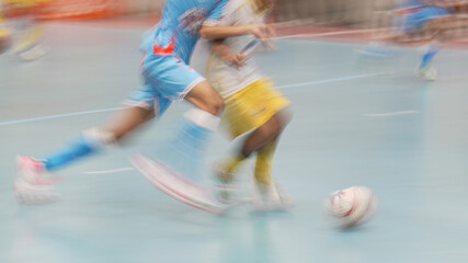 Naklejka premium Dynamic motion blur of futsal players competing for the ball