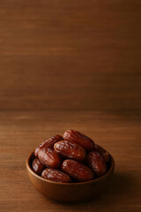 Obraz premium Dates Fruit in Wooden Bowl on Wooden Table