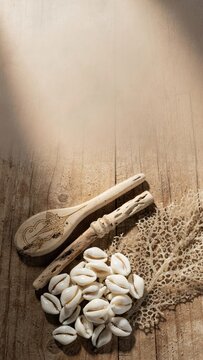 Cowrie shells and wooden spa tools on dark rustic background