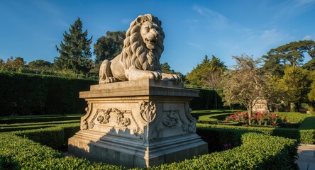 Obraz premium Stone lion monument resting on embellished plinth amidst garden setting