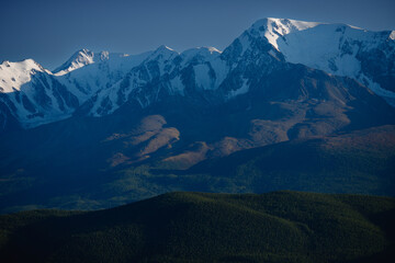 Fototapeta premium Majestic snow-capped Altay mountain range under clear blue sky at dusk