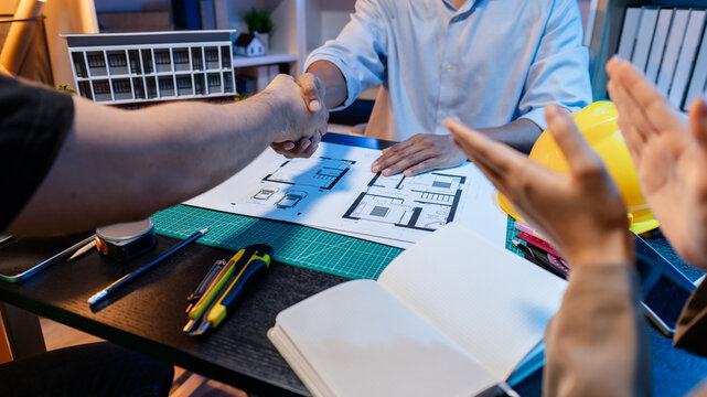 Engineers and architects analyze construction models and discuss project strategies, combining technical knowledge and creative ideas to achieve successful architectural design solutions.