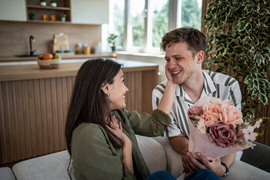 Happy couple celebrating love with a surprise flower bouquet