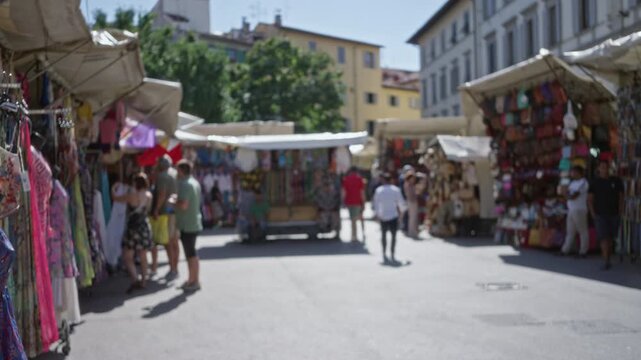 Blurred street market background with shallow bokeh and soft defocus on a sunlit street; background backplate copyspace calm.