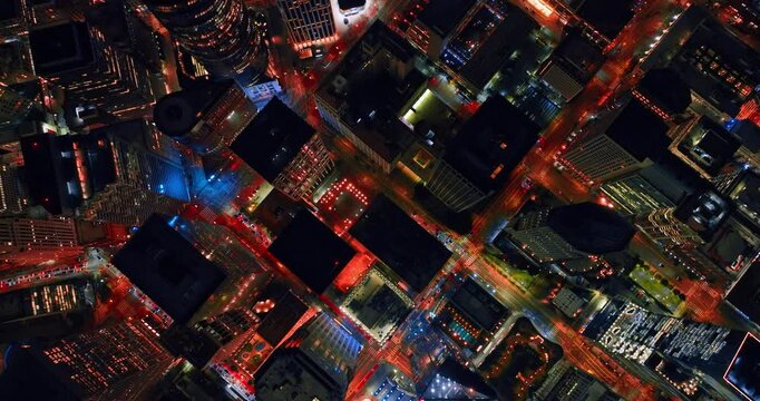 Flight over the rooftops of high-rises and skyscrapers in the scenery of San Francisco, California, USA. City lights of vibrant metropolis at night.