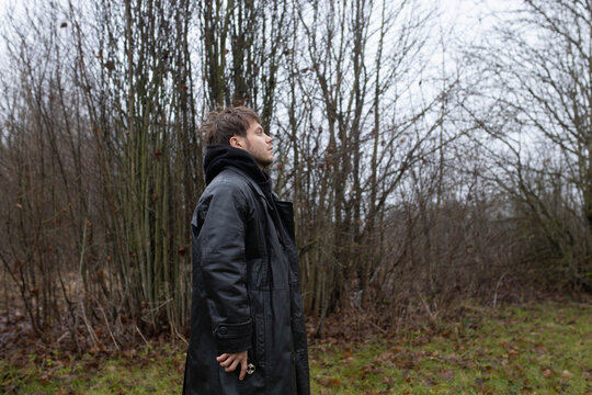 A man in a black leather coat in gloomy weather outdoors in an emotional crisis and sadness