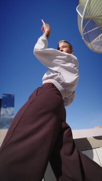 Stylish androgynous dancer performing contemporary moves outdoors