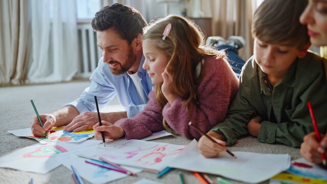Kids adults involved drawing at floor closeup. Sister brother creating pictures