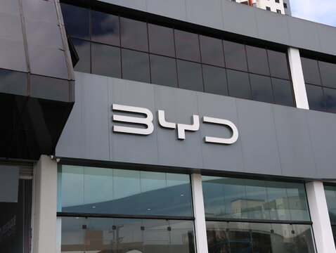 Logotipo da BYD na fachada de concession&aacute;ria em Mogi das Cruzes, SP, em 10 de junho de 2026, destacando marca automotiva, arquitetura moderna e mobilidade el&eacute;trica