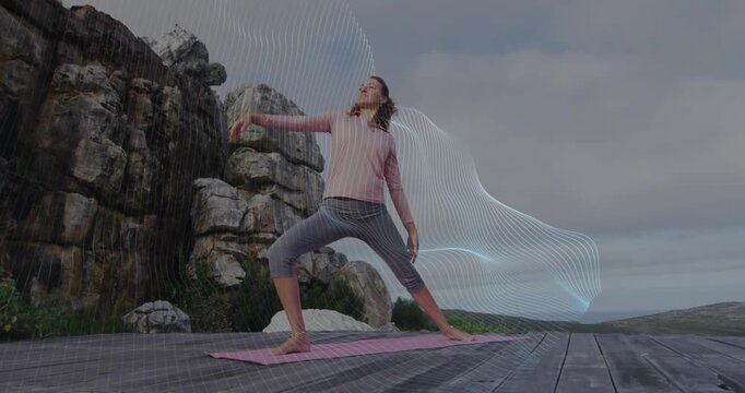 Woman practicing wellness reverse warrior yoga on coastal deck, with digital wave graphics rippling